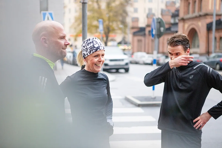 Tre människor i sportkläder i utomhusmiljö.