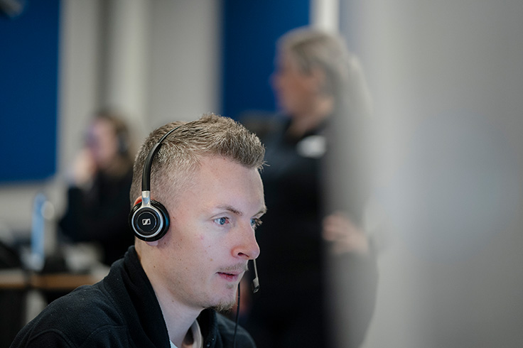 En manlig operatör med headset som svarar på 112-samtal.