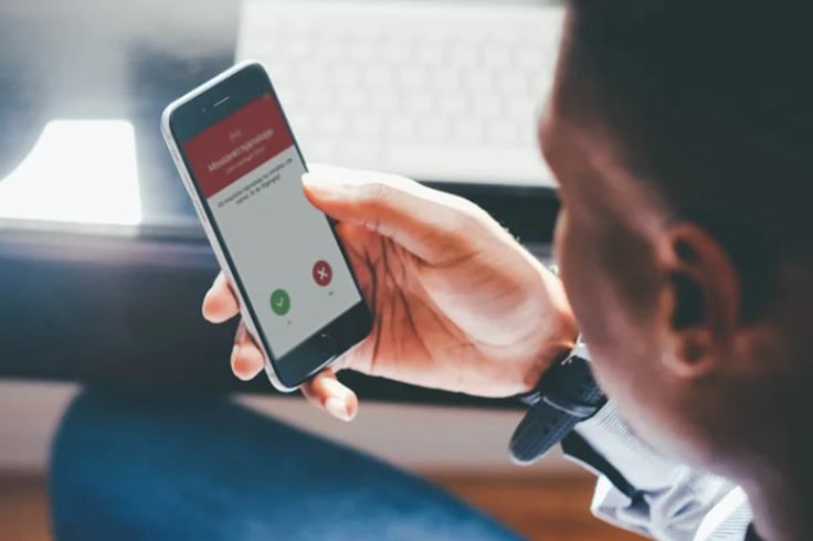 Person som håller i sin mobiltelefon och kollar appen sms-livräddare